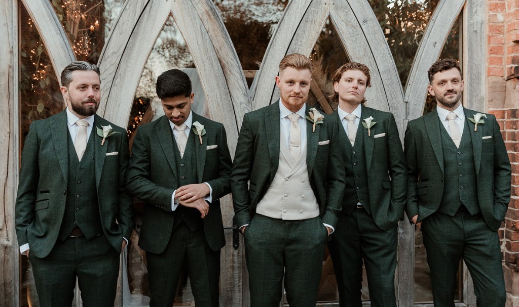 Wedding party in dark green three-piece suits with cream ties and boutonnieres, hired from Scotney's of London Road